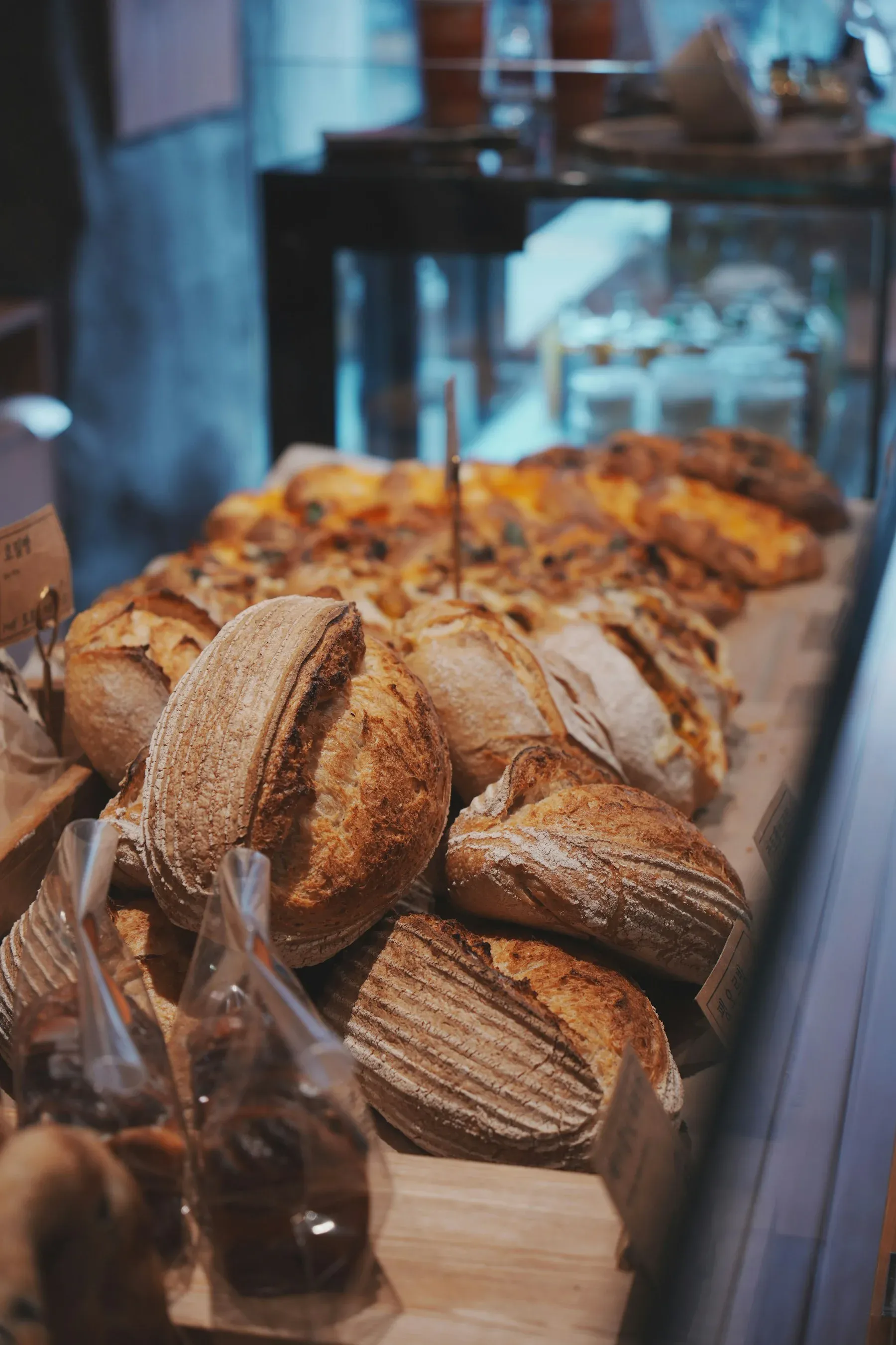 Flour-dusted artisan loaves on wooden bakery shelves